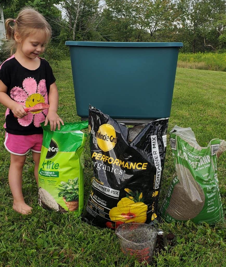 little girl standing next to tote, perlite, potting soil, and sand