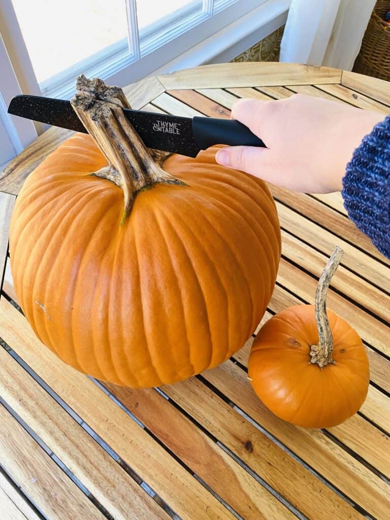 cutting a pumpkin stem with a knife